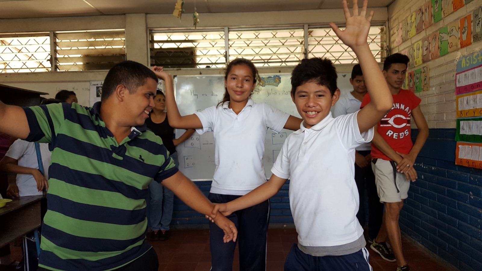 Students in classroom raising hands during lesson